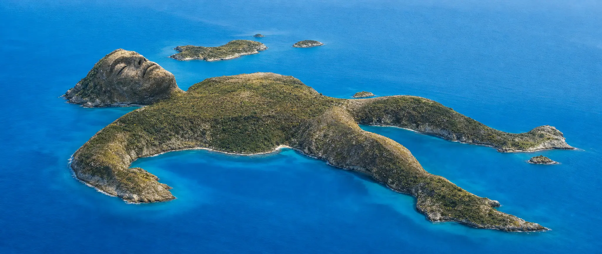 A view of islands shaped like sleeping giants in an azure sea
