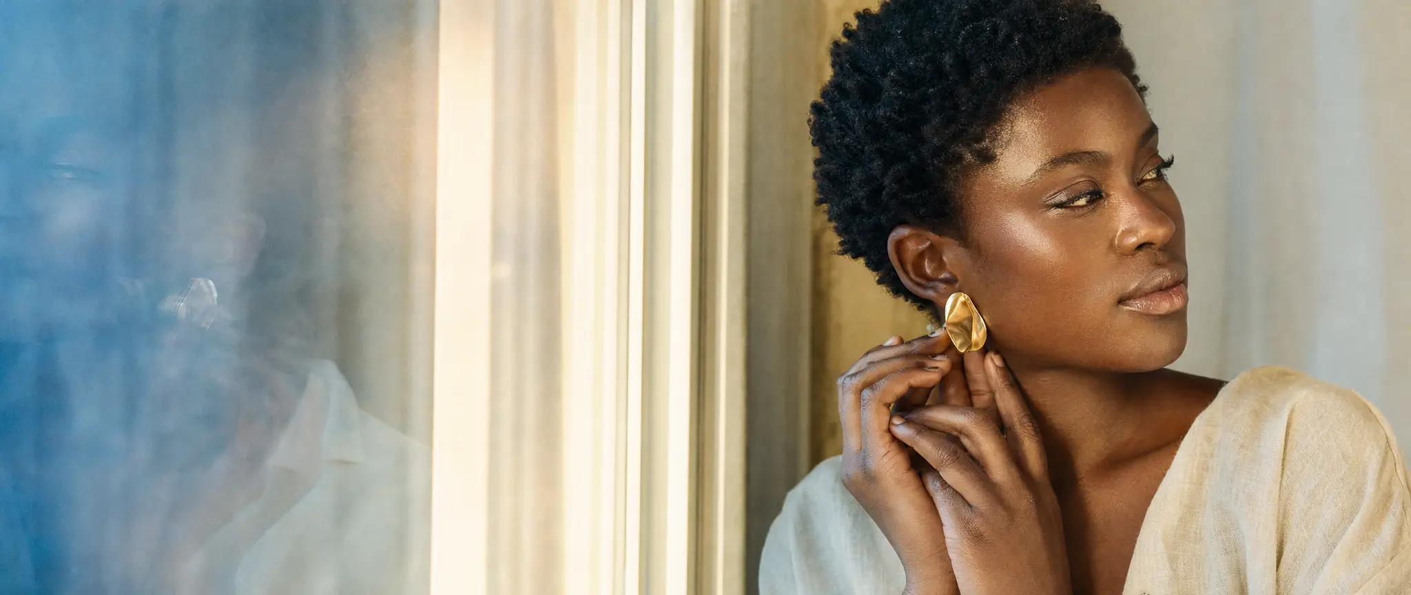 A beauty editorial portrait in warm window light and cool blue reflections