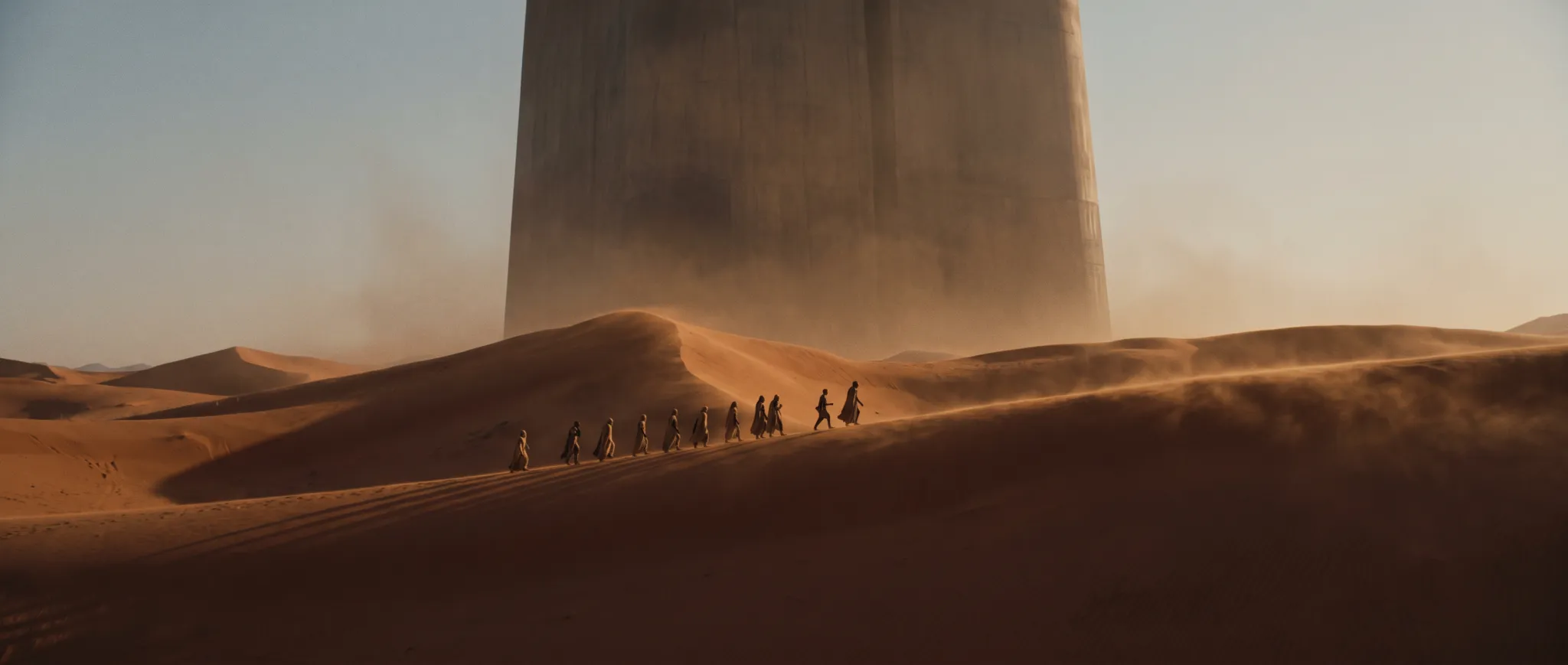 A small caravan crossing the Wadi Rum desert toward a distant monolith