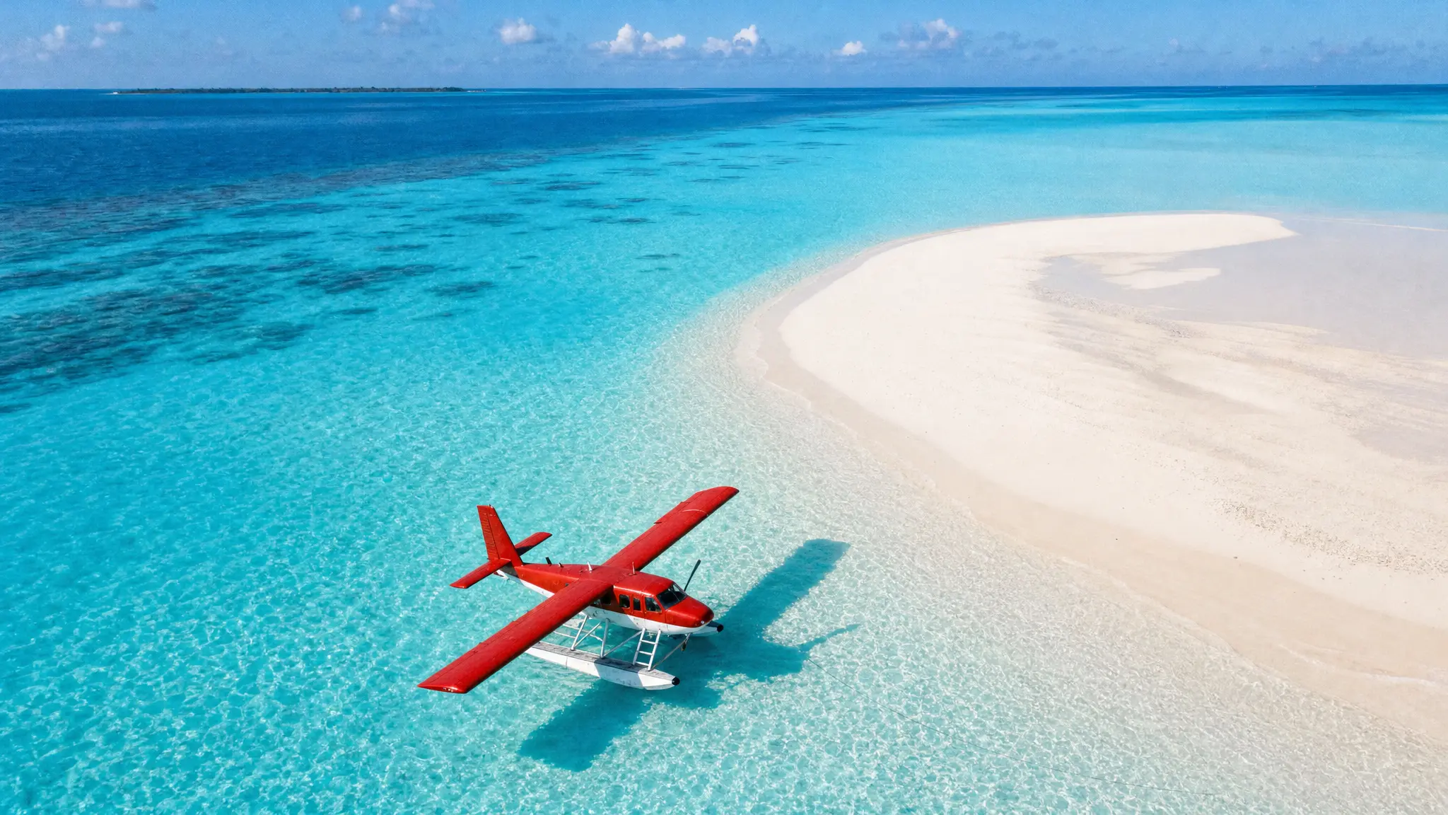 A red seaplane on an azure lagoon from above