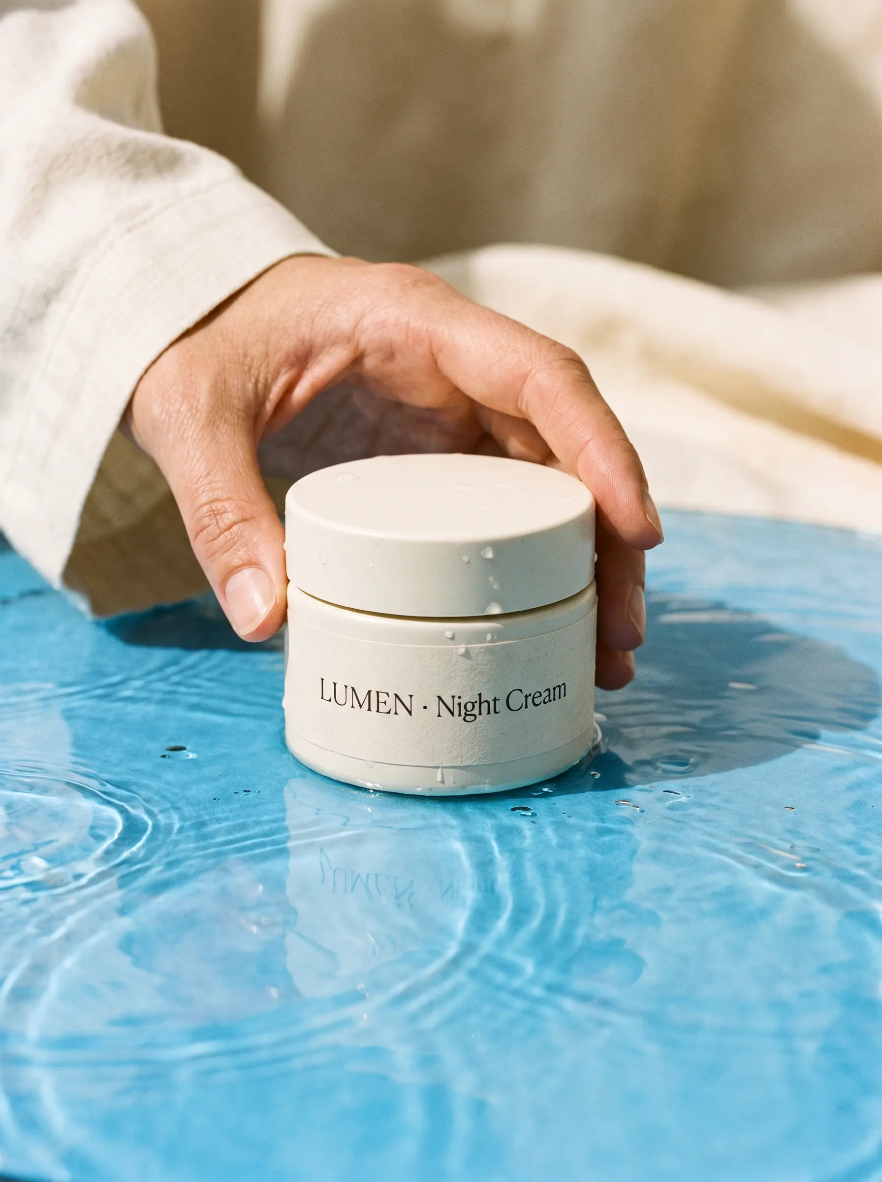 A matte ivory skincare jar with the label "LUMEN · Night Cream" in thin serif