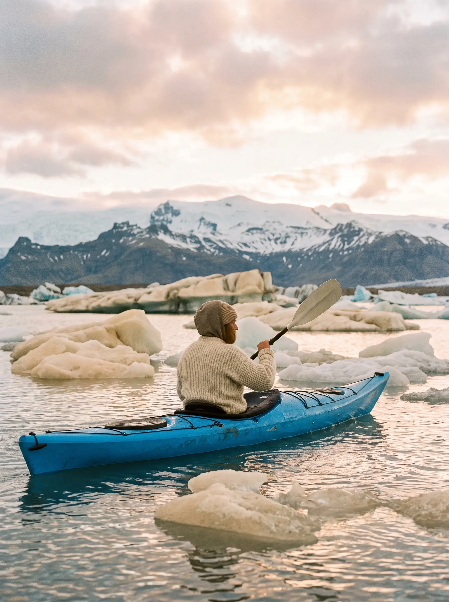 A glacier lagoon with icebergs at dawn and one azure kayak