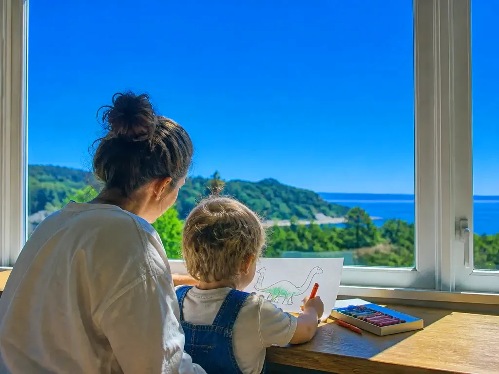 A parent and child colouring a printed page