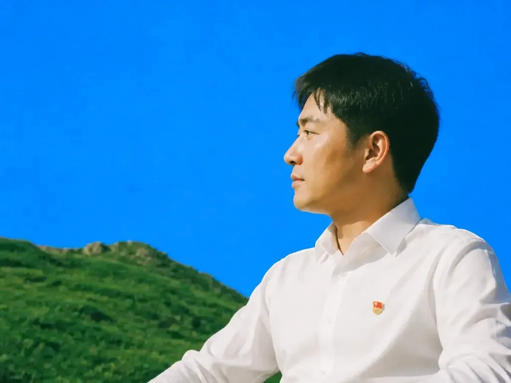 A man in profile against a blue backdrop