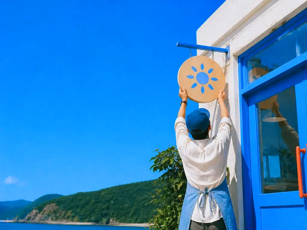 A café owner hanging a new sign
