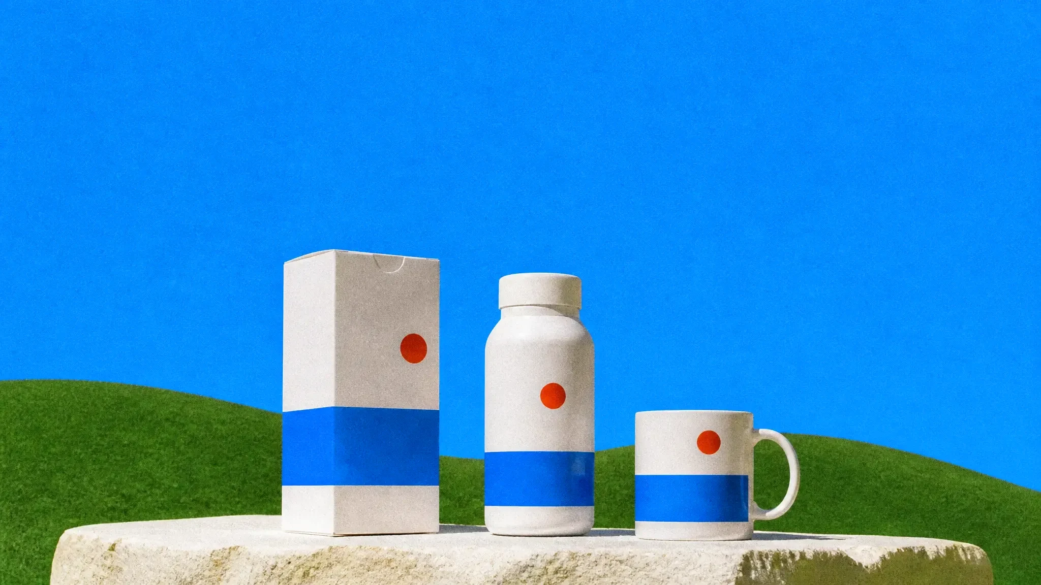A box, a bottle and a mug wearing the same label design on a stone plinth
