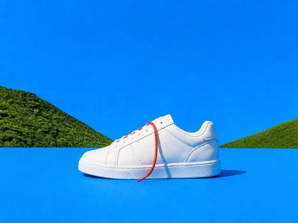 A white sneaker on a blue studio sweep