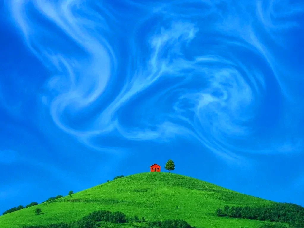 A hillside photo extending into wider panels