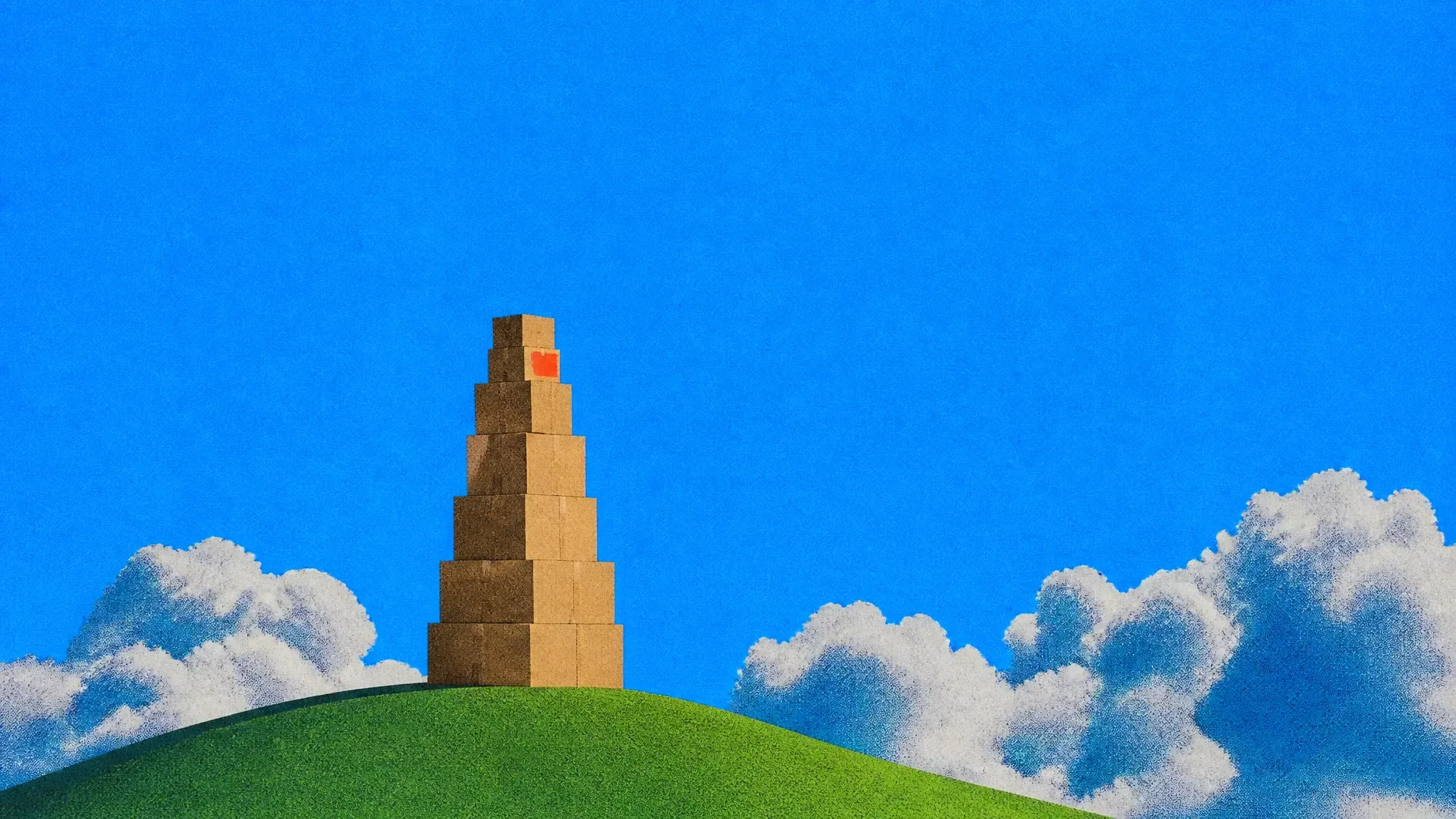 A giant tower of cardboard boxes on a green hill