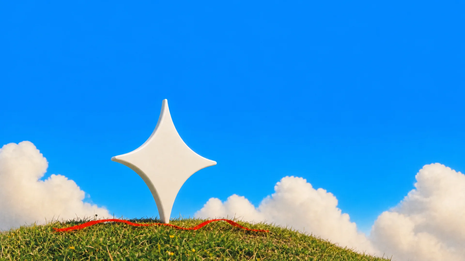 The Gemini spark as a white sculpture on a grassy hilltop under a blue sky, a red ribbon at its base