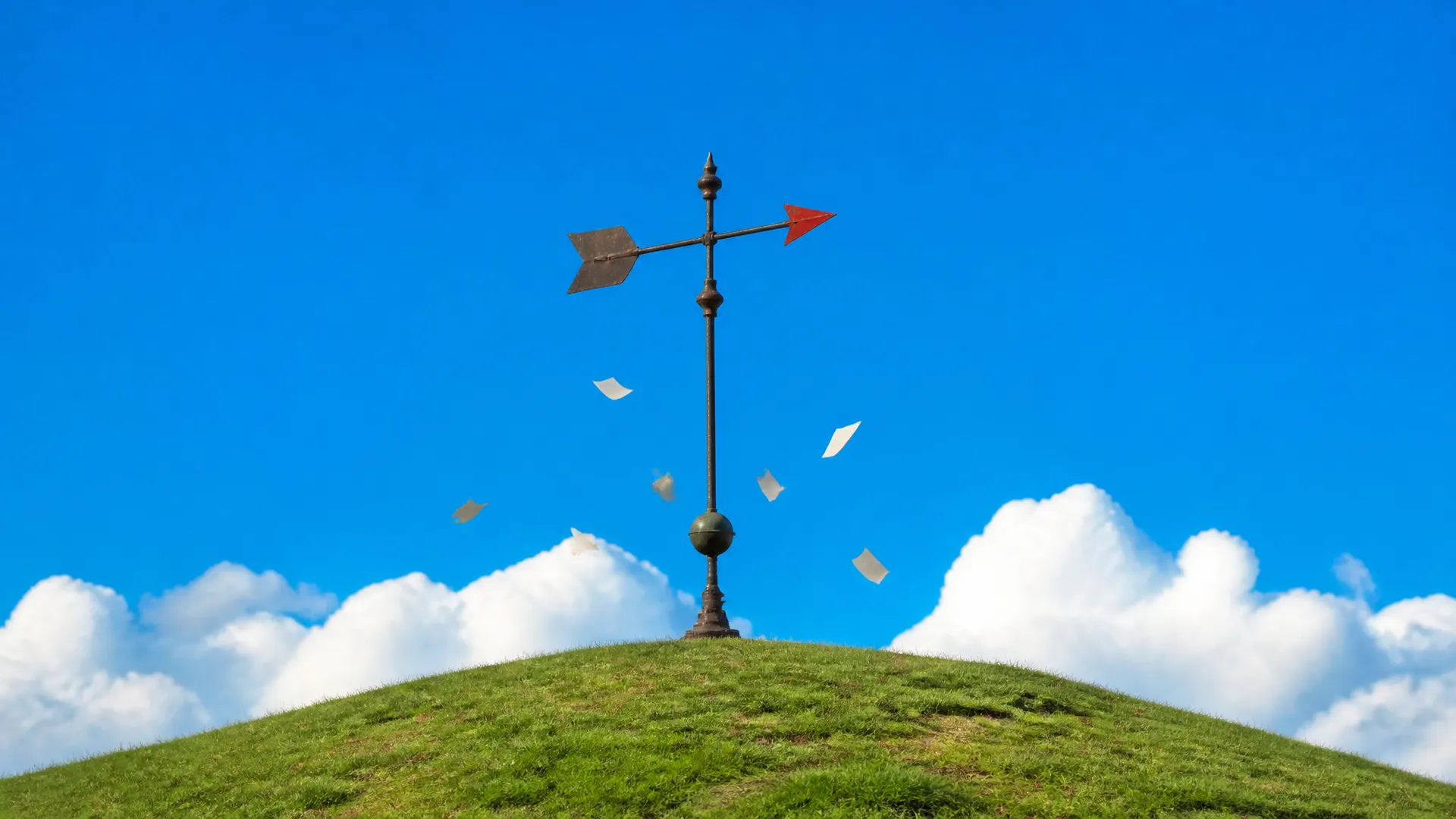 An iron weather vane with an orange arrow tip on a hilltop, small blank notes fluttering around it in the wind.