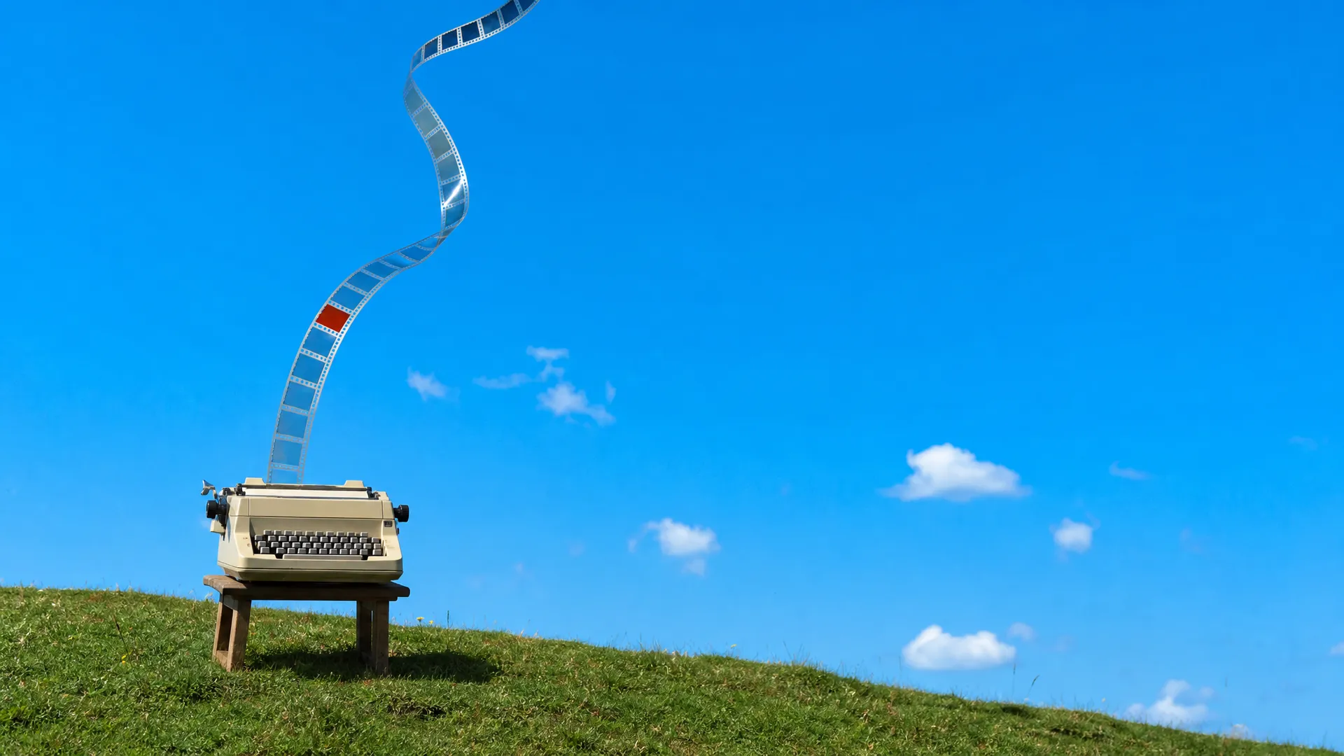 A vintage typewriter on a stool on a hilltop, a strip of film rising out of it into the sky