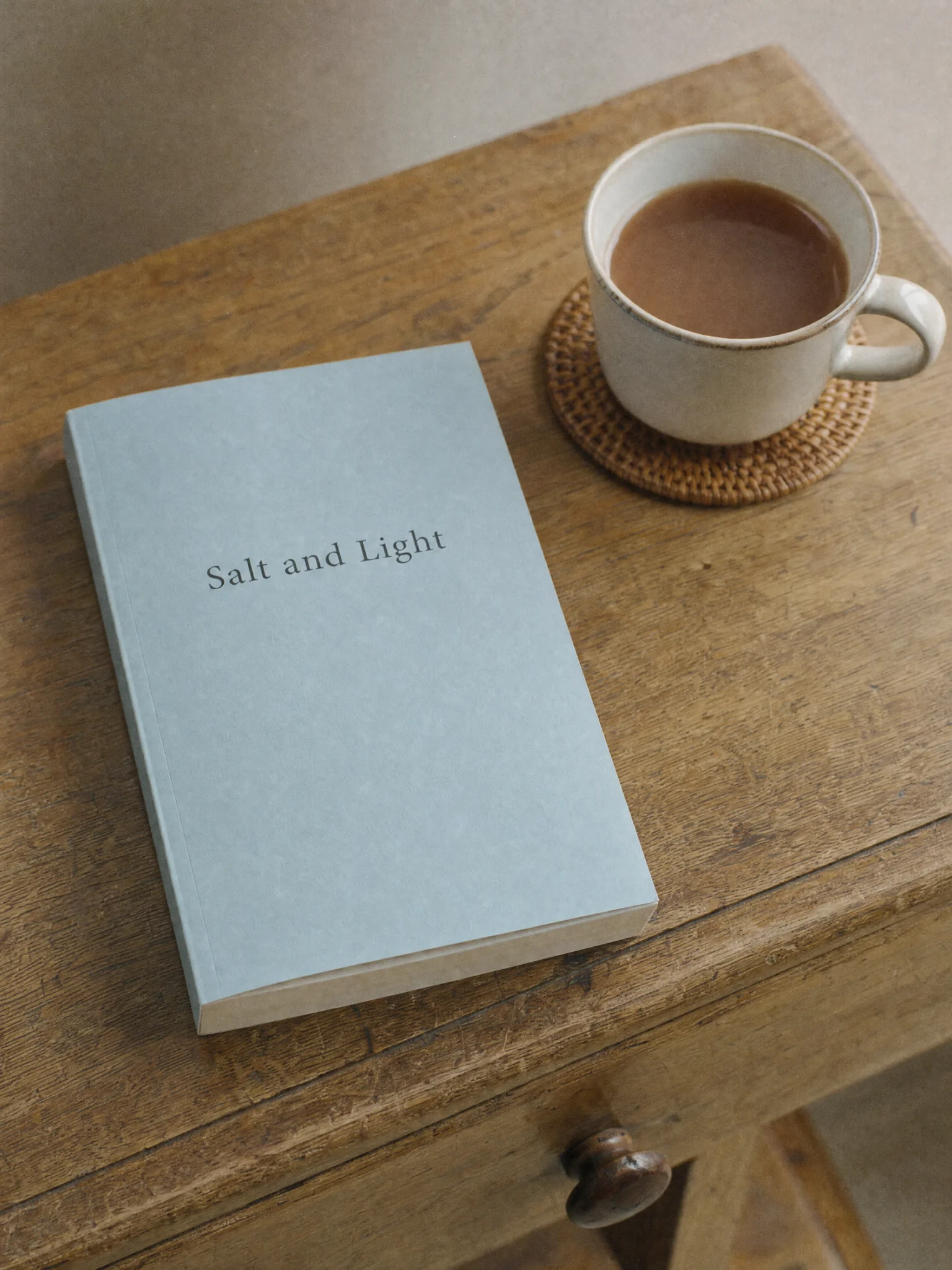 A paperback novel titled Salt and Light on a wooden table