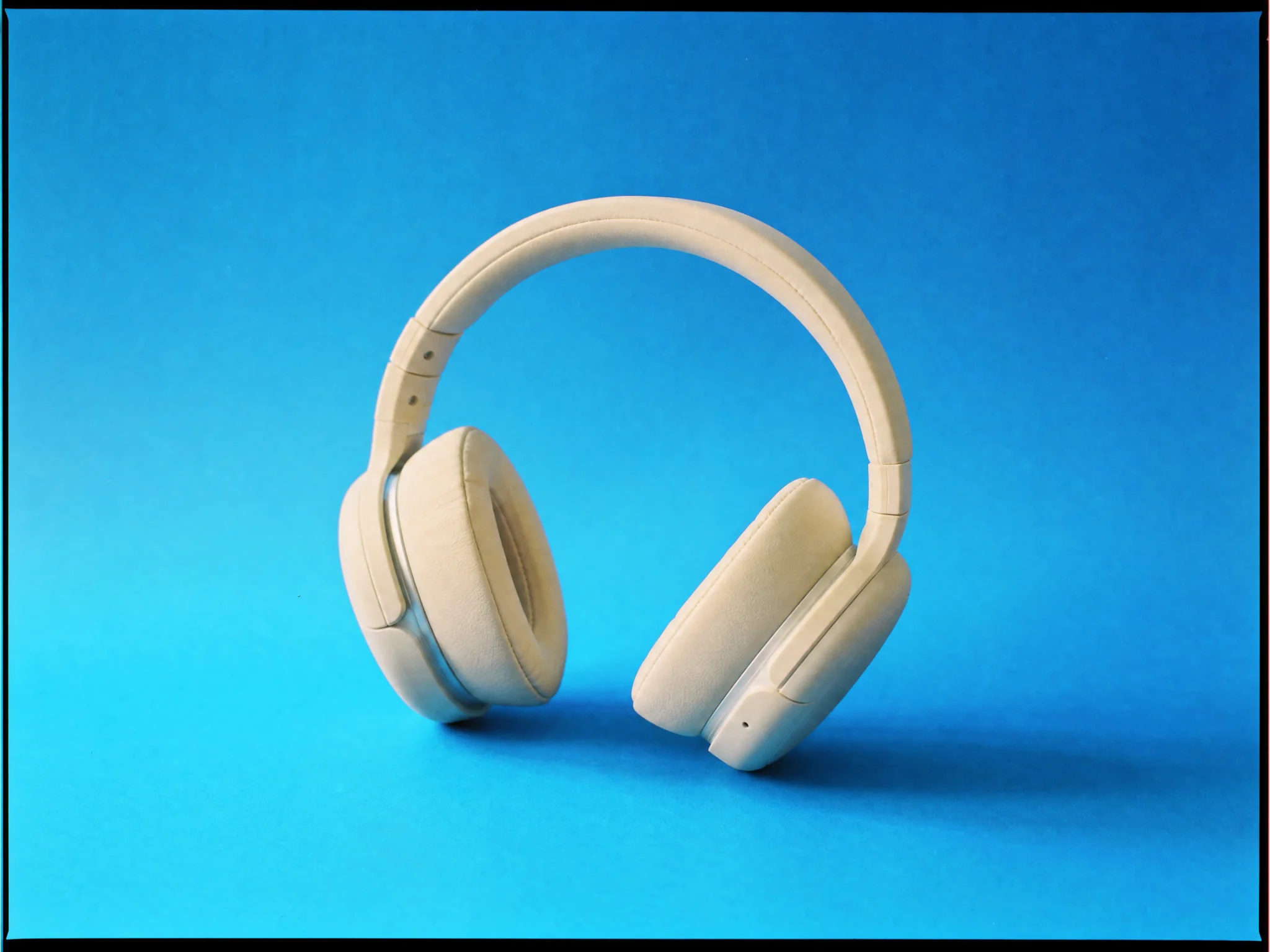 A product shot of headphones on a sky-blue backdrop