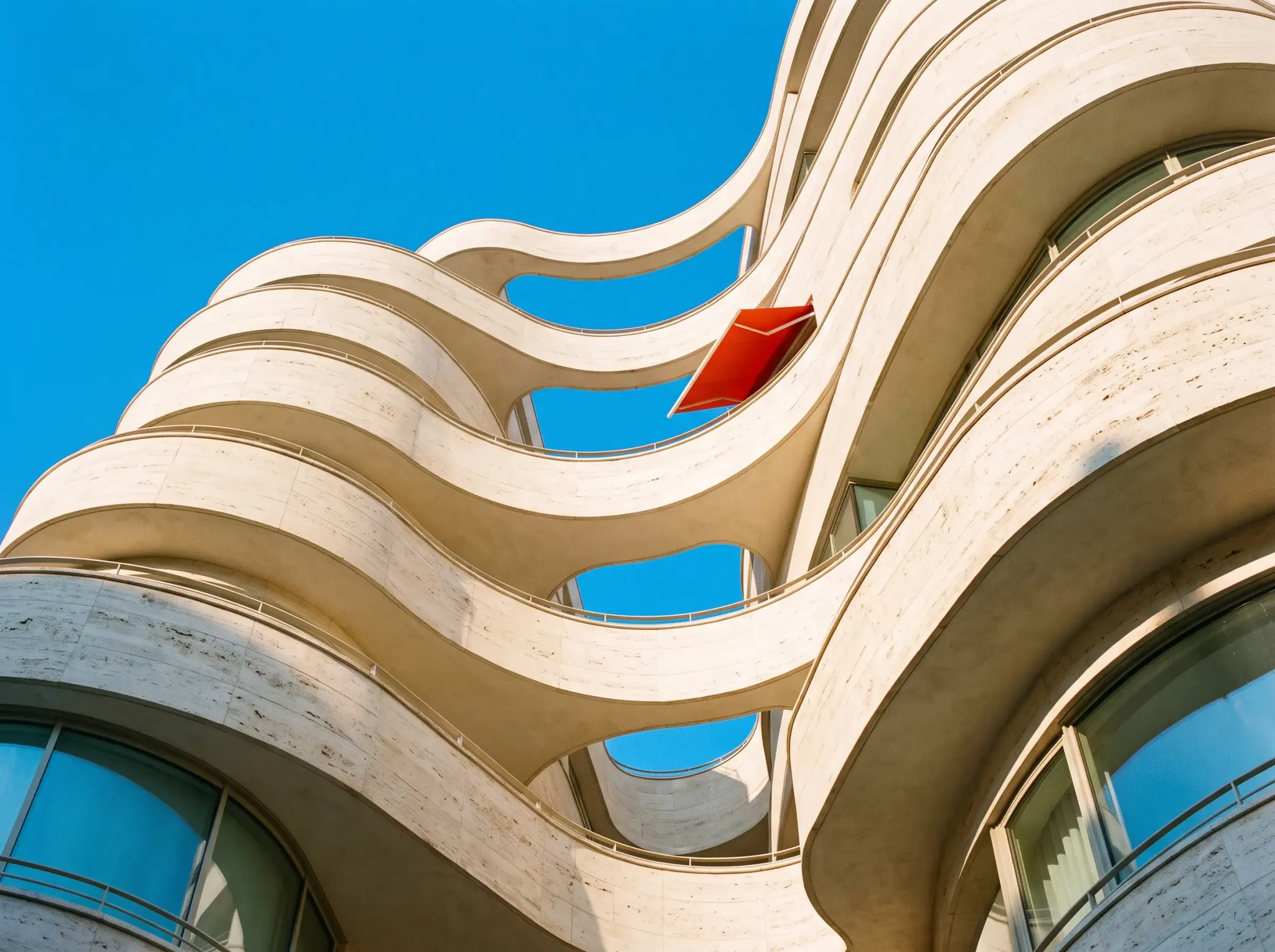 Wave-like limestone balconies against an azure sky