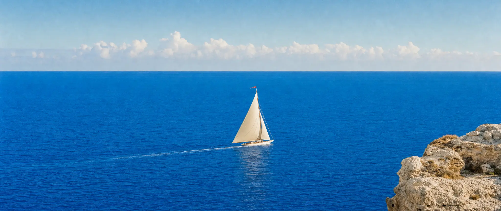 An ivory sailboat crossing a vast azure sea