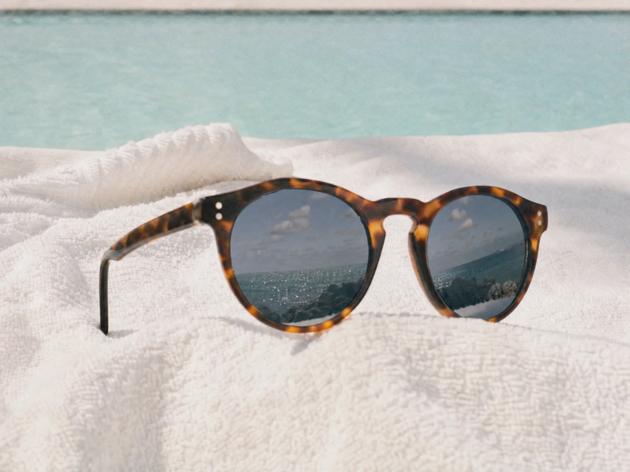 Sunglasses reflecting the sea