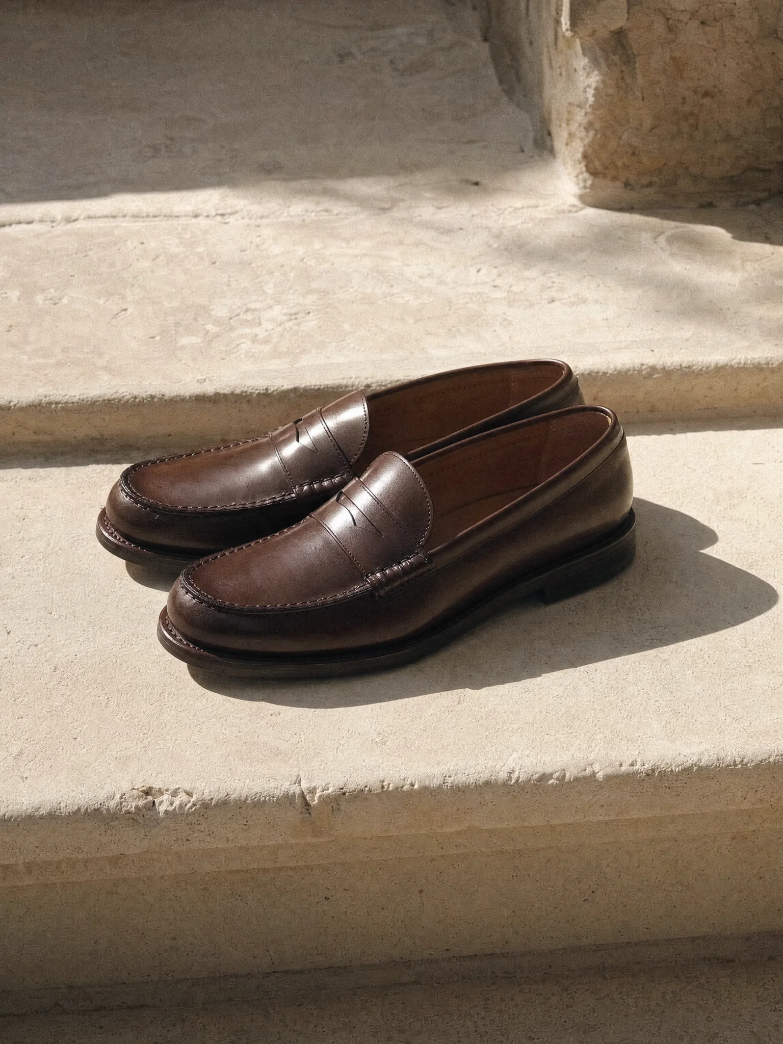 A pair of leather loafers on a stone step